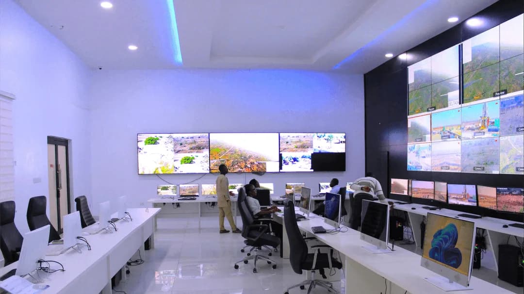 Surveillance control room with monitoring screens and workstations